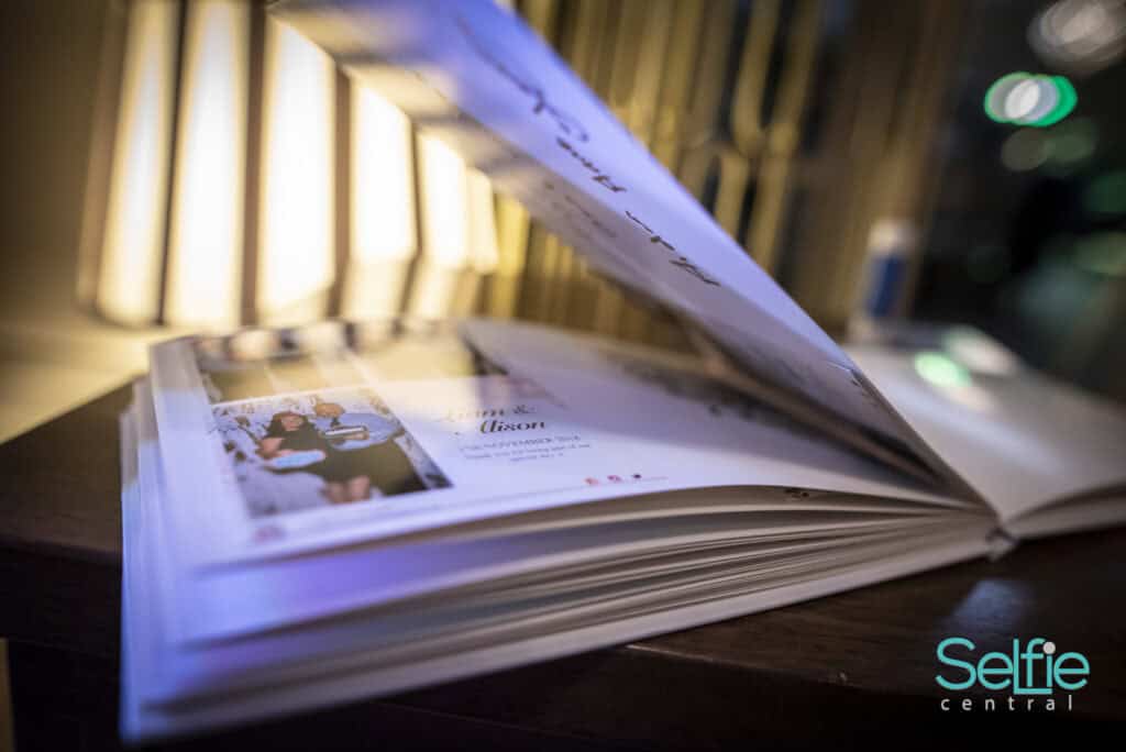 Open photo booth album with printed photos at Selfie Central in Auckland.
