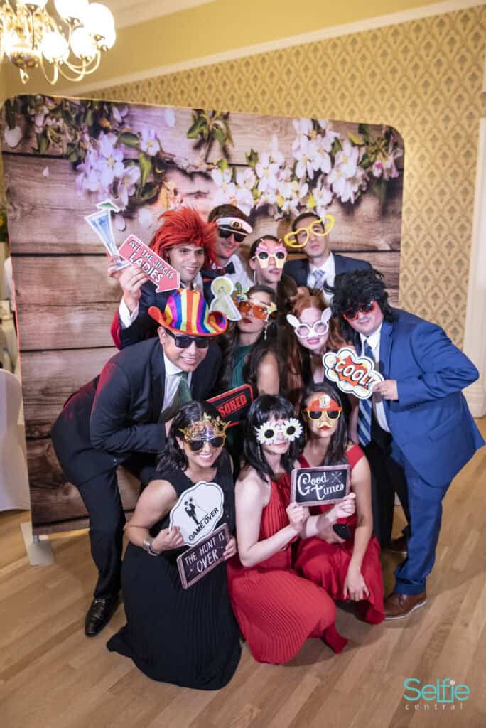 Group of people in colorful costumes and props at a photo booth in Auckland.