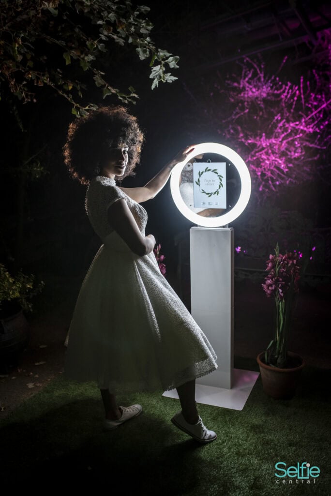 Girl using a photo booth with ring light at an Auckland event, capturing fun moments.
