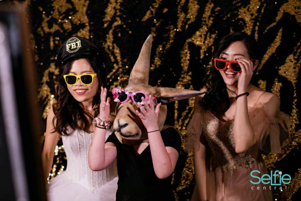 Group of friends in costumes and props at a photo booth event in Auckland.
