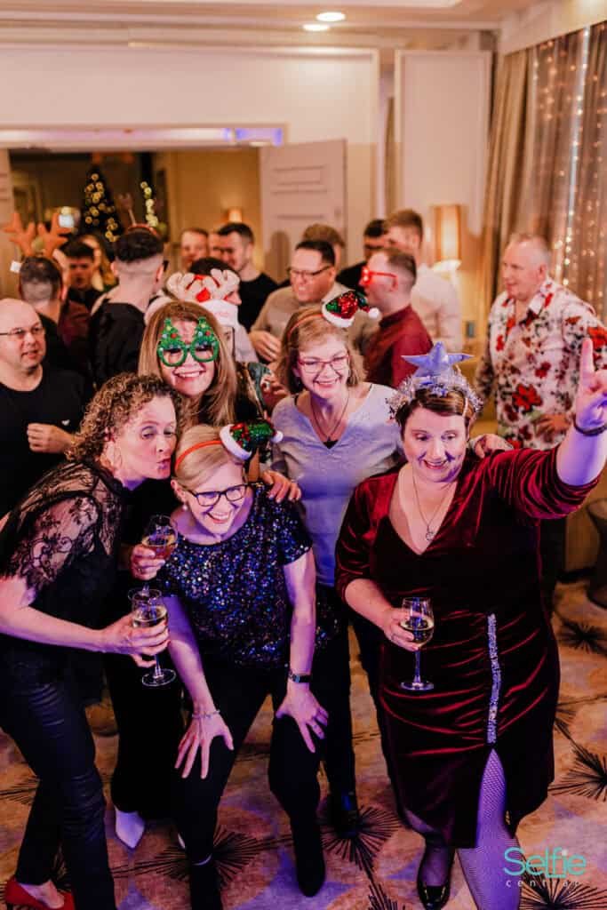 Group of people enjoying a photo booth at a lively Auckland celebration.