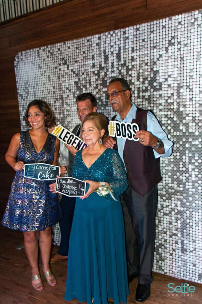 Group of diverse guests enjoying a photo booth at an event in Auckland, celebrating with fun props a.