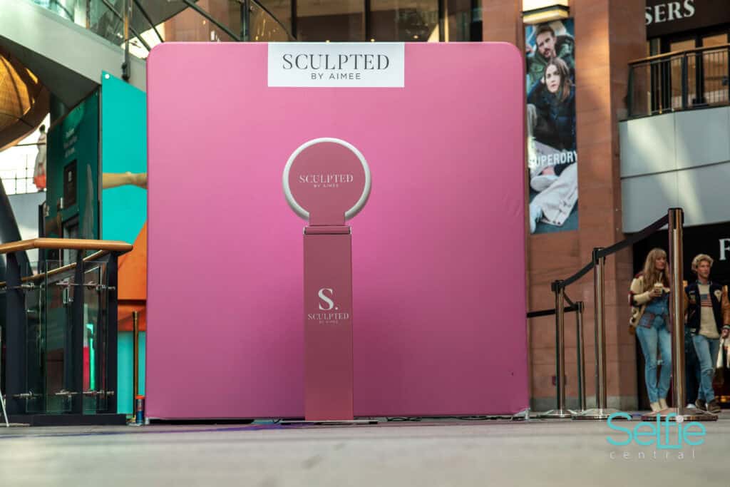 Photo booth with pink backdrop at Auckland event for selfies and photos.