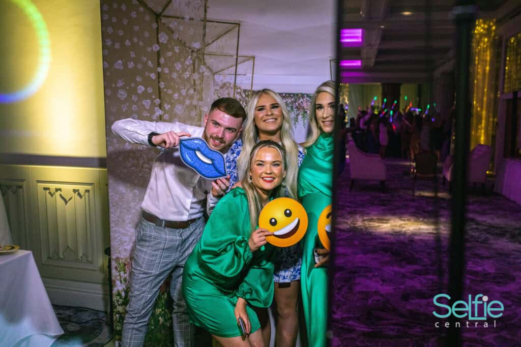 Group of friends enjoying a photo booth at an event in Auckland.