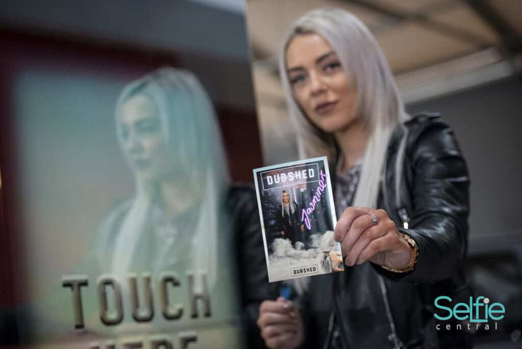 Young woman holding a photo strip at Selfie Central Auckland event.