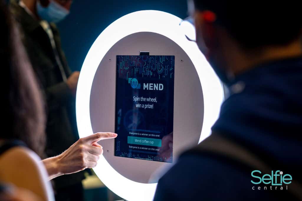 People using a digital spin wheel at Selfie Central photo booth in Auckland.