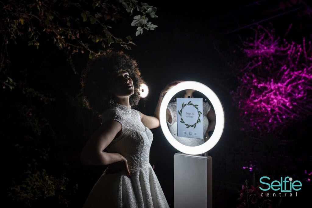 Woman using a photo booth with ring light at night in Auckland.